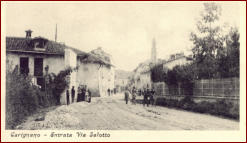 Entrando in Via Salotto da San Rocco Si può osservare il Campanile dei Battuti Neri, la recinzione di Villa Peliti, il lampione a gas sull’angolo tra via Salotto e via P. di Carignano, ghiaia per consolidamento del selciato, ciclisti e pedoni di passaggio